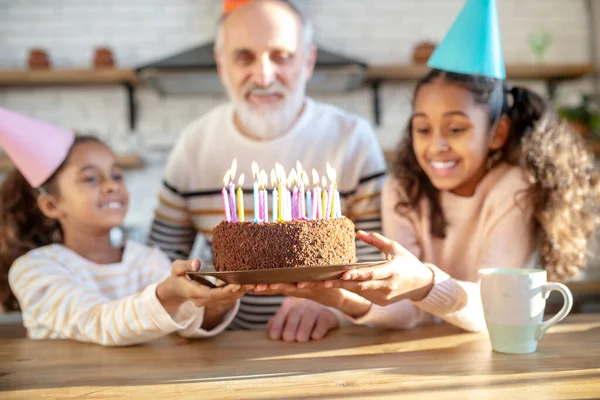 Dos chicas de piel oscura sosteniendo su pastel de cumpleaños abuelos —  Fotos de Stock