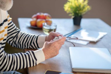 Adamın ellerinin kablosuz kulaklığı tutarken yakın plan fotoğrafı.