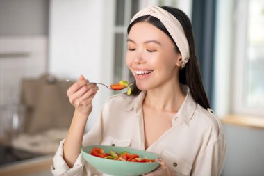 Sebze salatası yiyen güzel, neşeli genç bayan..