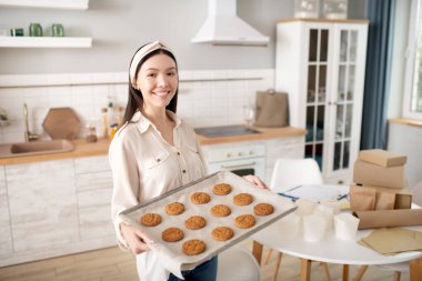 Masanın yanında yemek tepsisi olan başarılı bir kadın..