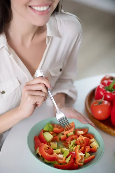 Salade fraîche tranchée dans une assiette dans la main de la jeune fille . — Photo