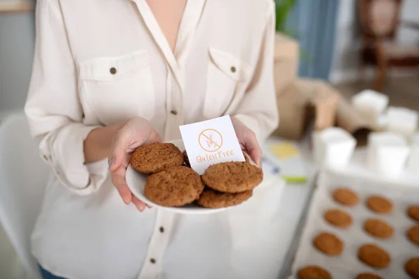 Soucoupe de biscuits sans gluten fraîchement cuits dans les mains des femmes . — Photo