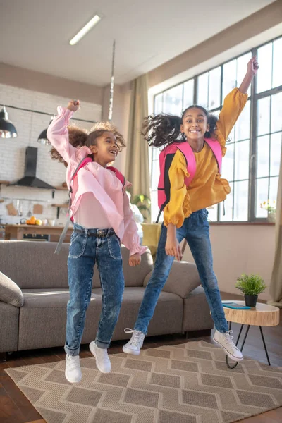 Dos lindas chicas de piel oscura saltando y sintiéndose felices — Foto de Stock