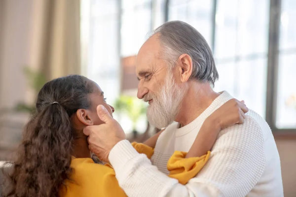 Uomo dai capelli grigi e una ragazza dalla pelle scura che sembra felice — Foto Stock