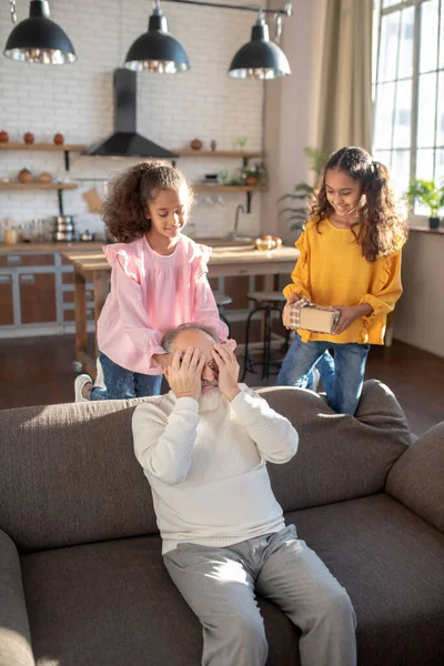 Gråhårig man i vit skjorta som sitter på soffan och blundar — Stockfoto