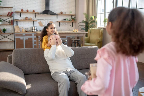 Niña linda de piel oscura sosteniendo un regalo de cumpleaños para su abuelo — Foto de Stock