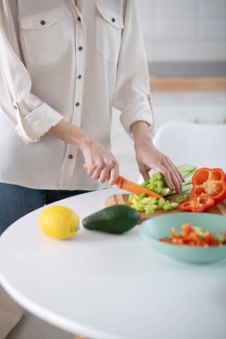 Bıçak, salata ve biber dilimleyen kadın elleri..