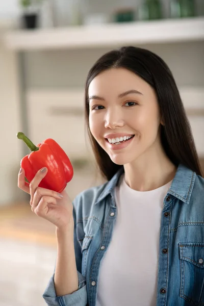 Mujer bonita joven con pimiento rojo en la mano . — Foto de Stock