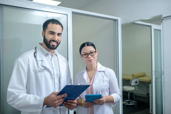 Bruni medici di sesso maschile e femminile in piedi nella stanza insieme — Foto Stock