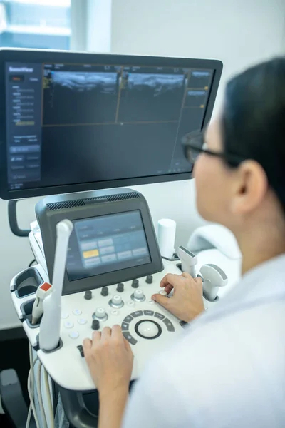 Médico de cabello oscuro con anteojos mirando al monitor —  Fotos de Stock