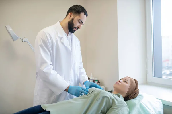 Dark-haired mammologist examining breasts of his patient — ストック写真