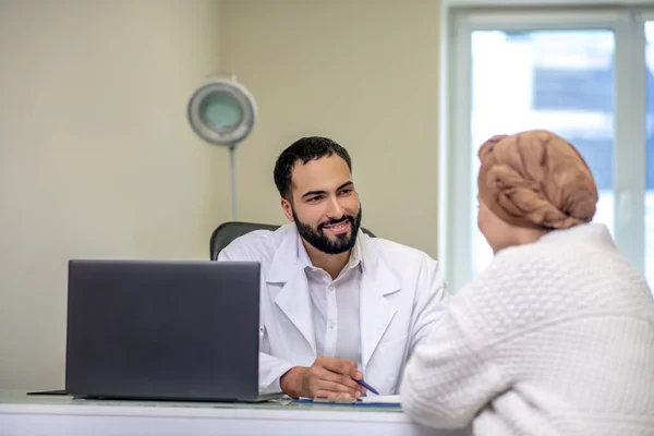 Médico varón consultando a su paciente en su consultorio — Foto de Stock