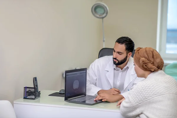 Medico maschio che mostra e spiega i risultati delle indagini al paziente — Foto Stock