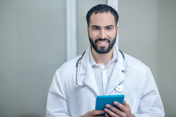 Maschio medico in una veste bianca sorridente e sentirsi bene — Foto Stock