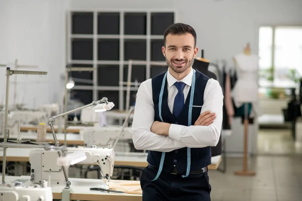 Male tailor standing with folded hands, smiling — Stock Fotó