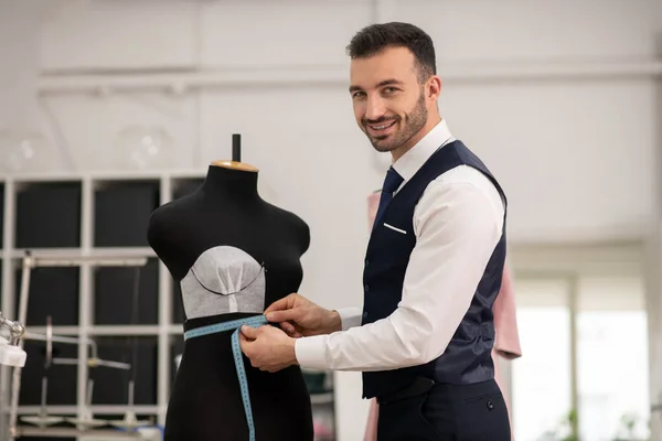 Male tailor measuring dummy size with measuring tape — Stock Fotó