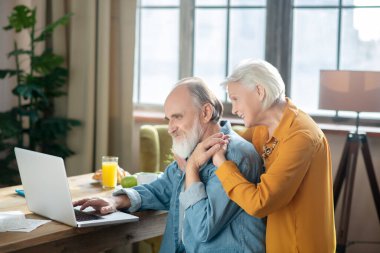 Mutlu yaşlı çift internette bir şeyler izlerken romantik hissediyor.