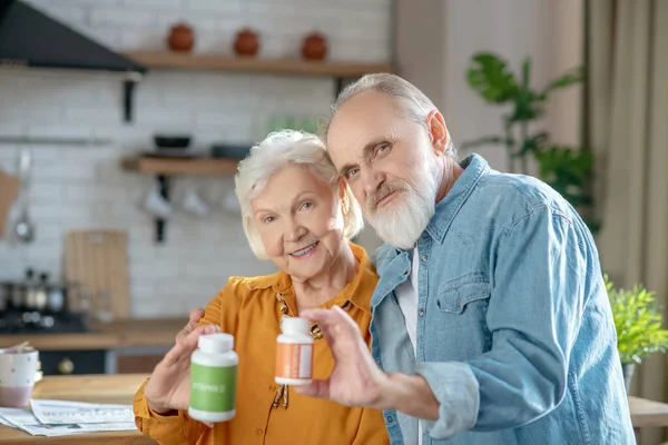 Idős házaspár, akik új kiegészítőket mutatnak be a jó egészség érdekében — Stock Fotó