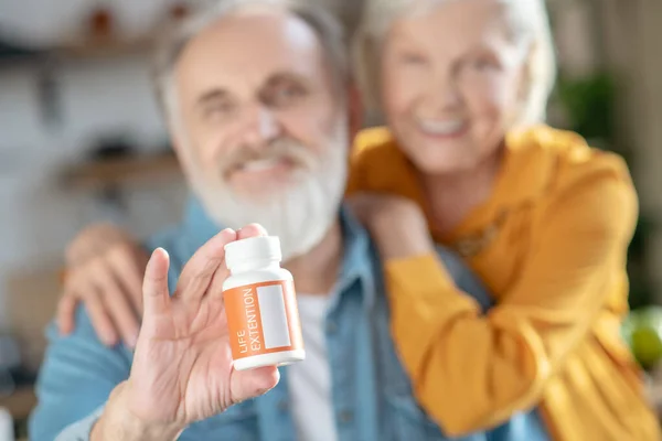 Ancianos casados feliz pareja demostrando nuevas vitaminas — Foto de Stock