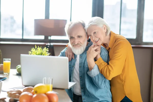 Feliz casal idoso sentindo grande assistir algo na internet — Fotografia de Stock