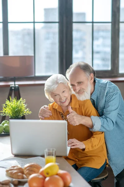 Fröhliches Senioren-Paar nutzt Computer — Stockfoto