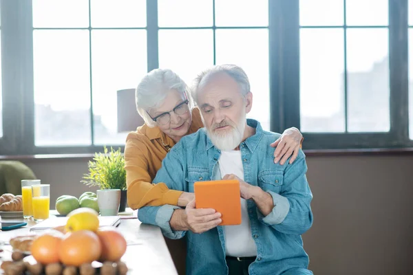 Senioren probieren gemeinsam eine neue Tablet-App aus — Stockfoto