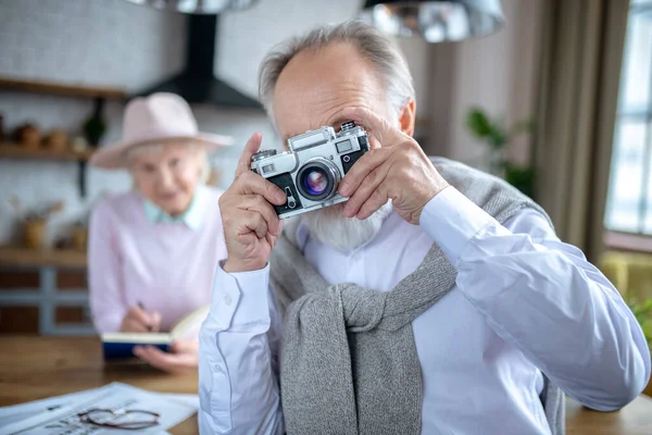 Alegre anciano utilizando la vieja cámara de cine —  Fotos de Stock