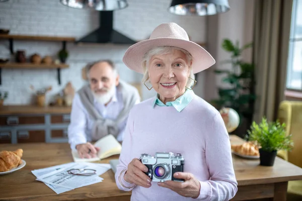 Sorrindo elegante mulher idosa segurando uma câmera de filme — Fotografia de Stock