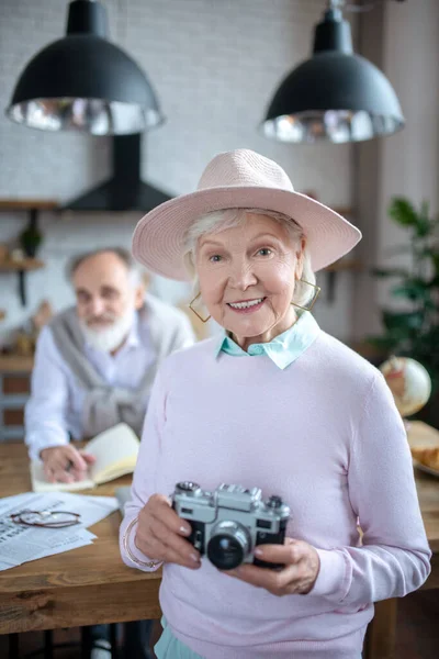 Sorrindo mulher idosa usando uma câmera de filme — Fotografia de Stock