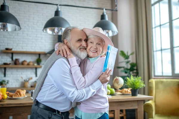 Przytulanie starszej pary trzymającej karty pokładowe — Zdjęcie stockowe