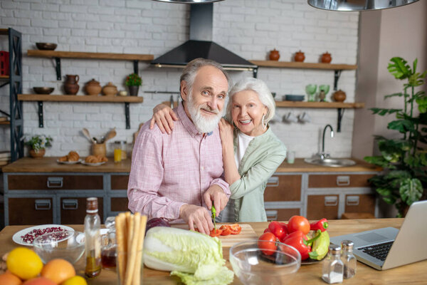 Elderly woman teaching her husband how to cook