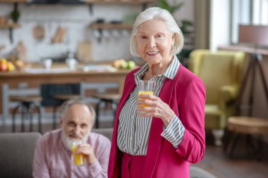 Married senior couple having orange juice together