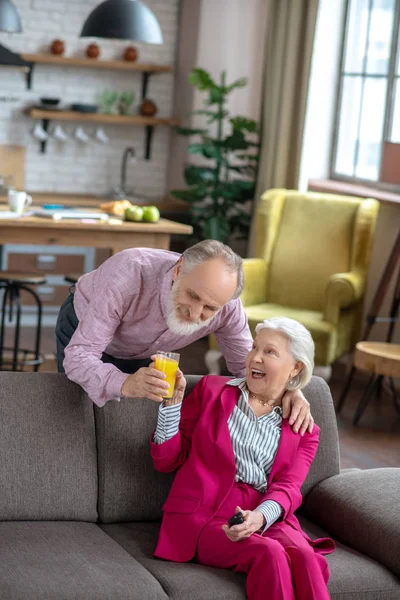 Casado pareja mayor sonriendo y teniendo jugo de naranja — Foto de Stock