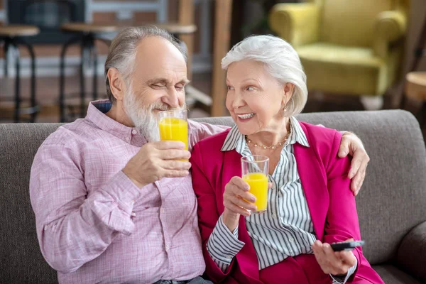 Married senior couple having orange juice and smiling — Zdjęcie stockowe