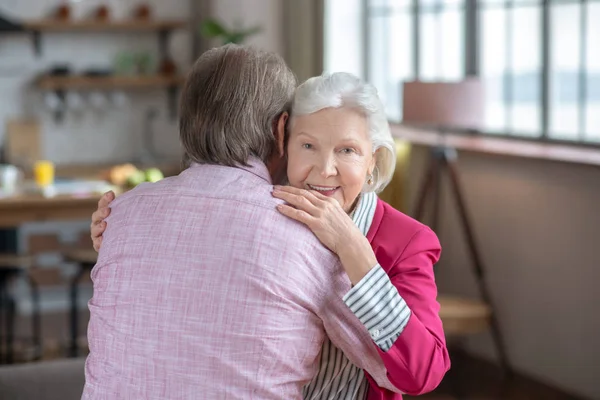 Grey-haired woman hugging her husband and feeling happy — Φωτογραφία Αρχείου