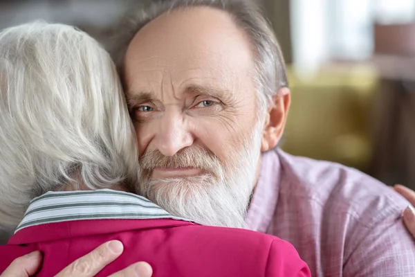 Grey-haired man and woman hugging each other — Stockfoto