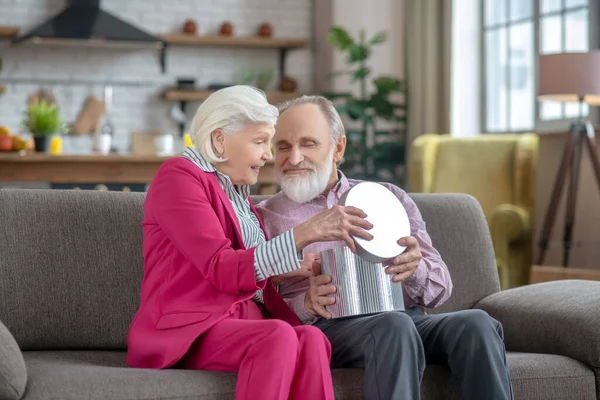 Mujer mayor de pelo gris dando un regalo a su marido — Foto de Stock