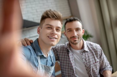 Young gay couple making selfie and feeling happy
