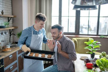 One man with baking sheet and another admiring this beautiful pastry.