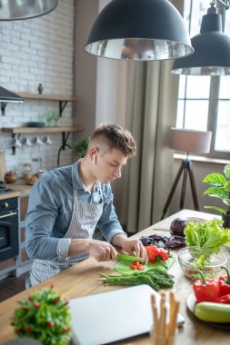 Attractive young man cooking a vegetable dish.