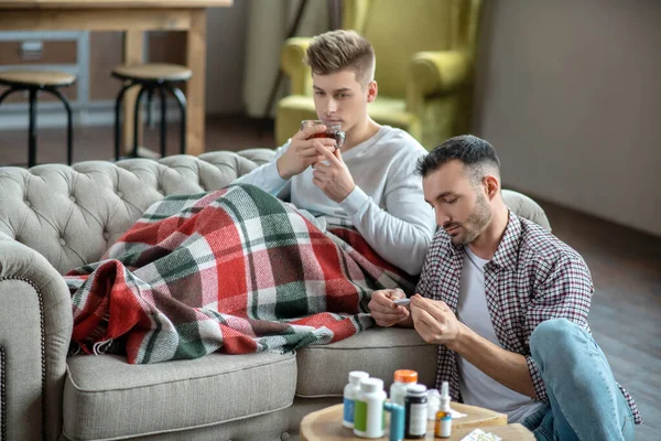 Giovanotto in camicia a scacchi a controllare la temperatura — Foto Stock