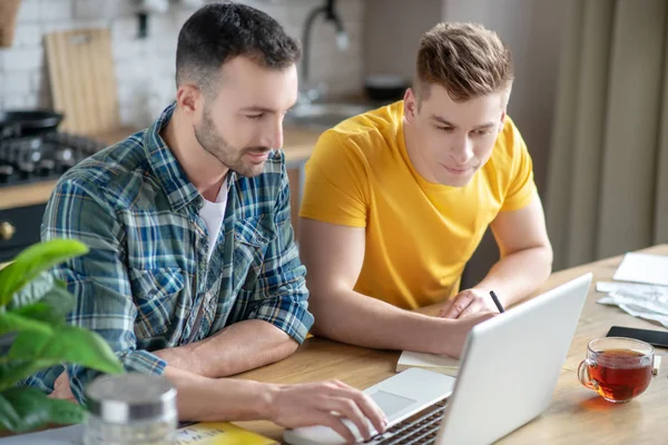 Deux jeunes hommes regardant le webinaire et regardant intéressés — Photo