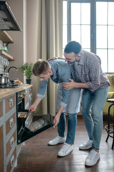 Dos hombres en estrecha relación de pie y mirando al horno . —  Fotos de Stock