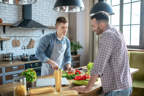 Two men standing opposite each other near the kitchen table. — Stockfoto