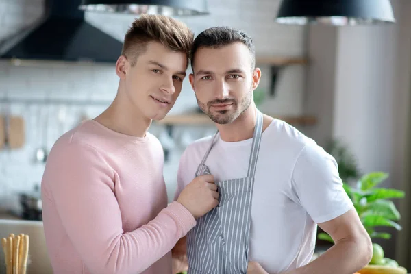 Two young guys standing close together in a room. — Stockfoto