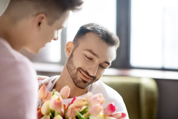 Deux jeunes hommes et un bouquet de fleurs . — Photo