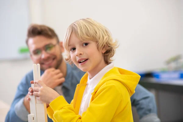Αγόρι που φτιάχνει μπλοκ, δάσκαλος που τον κοιτάζει, χαμογελάει — Φωτογραφία Αρχείου