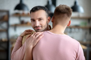 İki genç adam birbirine sarılıyor ve harika hissediyorlar.