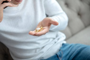 Beyaz tişörtlü genç adam telefonla konuşuyor.