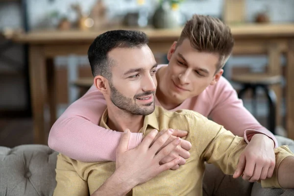 Young fair-haired man putting hand on his partners shoulder — Stock Photo, Image